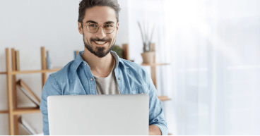 A smiling man with a laptop A smiling man with glasses and laptop
